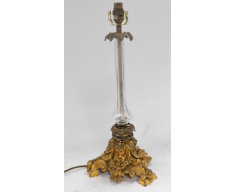 A Victorian cut glass and brass candlestick, converted to a table lamp, raised on a gilt brass base, embossed with fruit and 