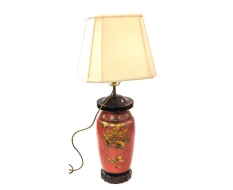 A Japanese red and gilt lacquer table lamp, decorated in bass relief with birds and flowers, raised on a hardwood stand, with