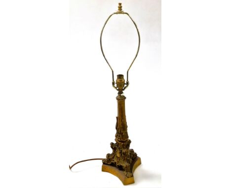 A late 19thC brass candlestick base, converted to a table lamp, of rococo form, raised on a triform base, 69cm high.