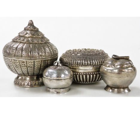 Four Indian white metal trinket boxes, one of cylindrical form, with a conical lid, with incised decoration, 8cm high, anothe