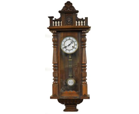A late 19thC oak cased Vienna wall clock, circular brass dial with enamel chapter ring bearing Roman numerals, eight day move