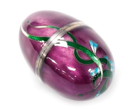 An Elizabeth II silver and enamel egg shaped trinket box, decorated with blue flowers and leaves against a purple ground, wit