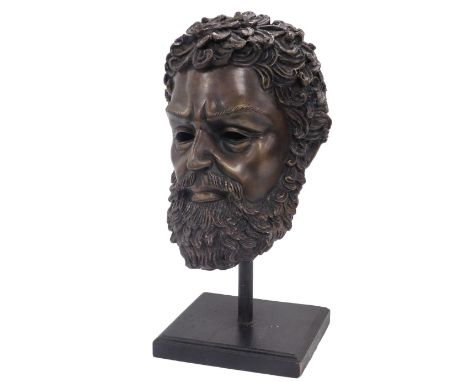 A bronze hollow cast bust of Zeus, raised on a pole and square ebonised base, 43cm high.