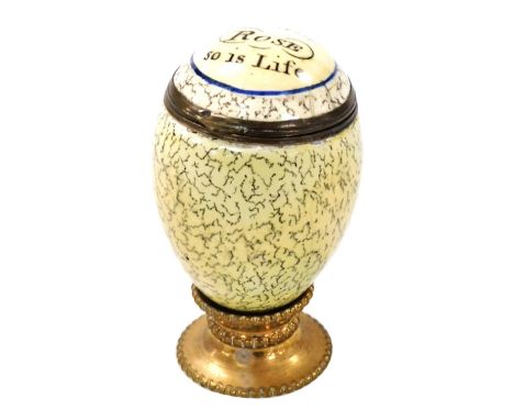 A late 18thC Bilston enamel nutmeg grater, modelled as an egg, the hinged lid decorated with 'As The Rose, So Is Life', grate