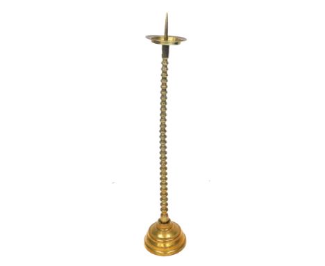 A Victorian brass pricket candlestick, with foliate engraved drip tray, over a ring turned column and circular engraved base,