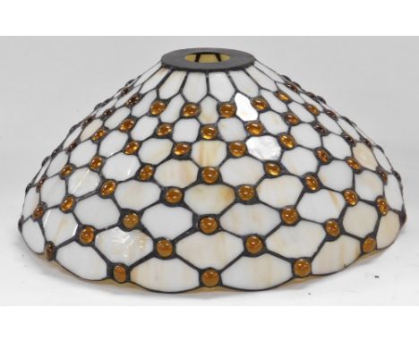 A Tiffany style light shade, of tapering form, decorated with amber roundels against a cream ground, 38cm diameter.