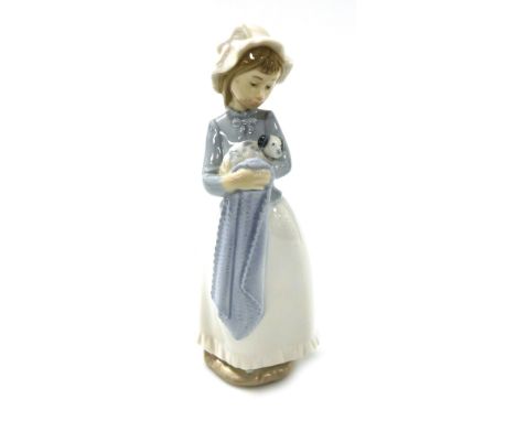 A Nao porcelain figure of a girl, modelled standing wearing a mobcap, with a puppy in her arms and draping blanket. 