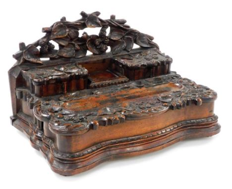A Victorian carved oak desk stand, the back carved with branches and leaves, above two small drawers, the tops carved with le