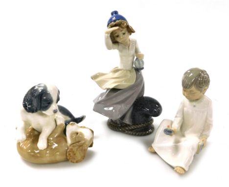 Three Nao porcelain figures, comprising a girl standing at a quayside looking out to sea, seated boy with chamber stick and b