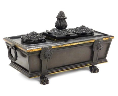 A late 19thC bronze desk stand, formed as a sarcophagus, with twin ring handles, the top with a central pineapple finial encl