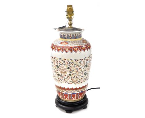 A Chinese ceramic table lamp, of shouldered vase form, decorated with a band of flowers and scrolling leaves against cream gr