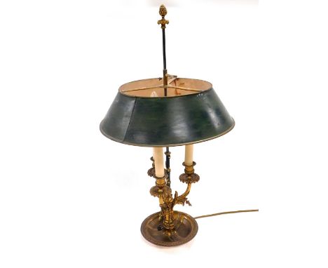 An early 20thC Continental brass three branch table lamp, with a green painted tin shade, raised on a leaf enveloped column w