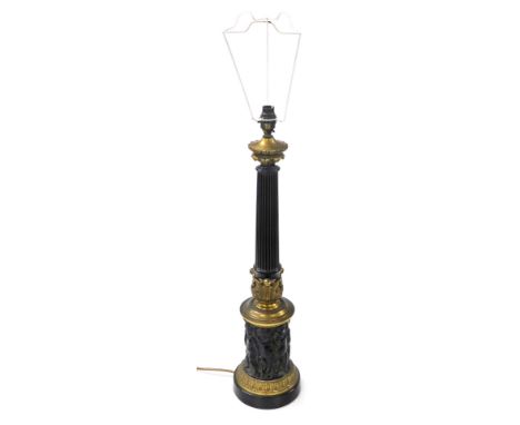 A late 19thC brass and ebonised lamp base, of fluted column form, above a repeating frieze of putti, raised on a socle base, 