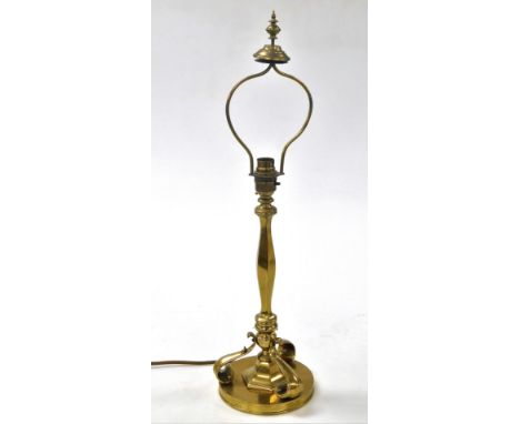 A late Victorian brass lamp, converted for electricity, of hexagonal form, raised on three scroll feet above a circular base,
