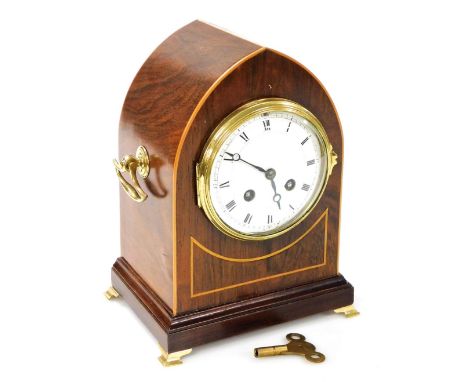 An Edwardian mahogany and boxwood inlaid mantel clock, of arched form, the Roman numeric enamel dial with eight day movement,