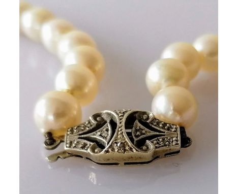 An Art Deco single row of fifty-one graduated cultured pearls measuring approx. 7.96mm to 10.35mm diameter, clasp set with ei