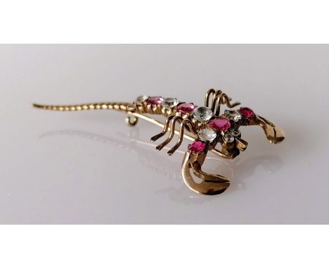A ruby and diamond scorpion brooch on a gold base, 5.5 cm, unmarked, approximately 0.60 carats total diamond weight and 0.50 