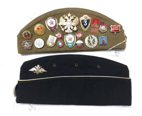Soviet Red Army "Pilotka" Side Cap covered with Soviet metal badges and cloth insignia and a Red Navy Officers Pilotka Side c