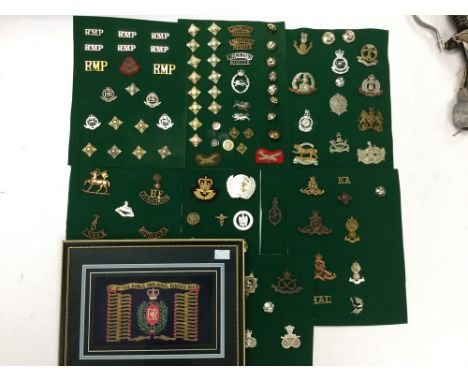 A collection of British WW1, WW2 and later cap badges and brass shoulder titles including GRV Army Remount Service, ten RA it