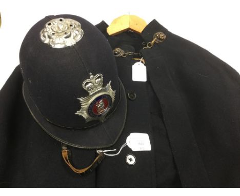 A British Policemans helmet with a Queens Crown enamel Warwickshire Constabulary cap badge complete with liner and chistrap, 