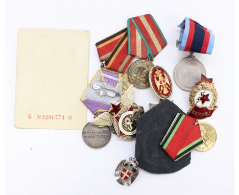 A collection of Soviet and Russian medals and badges to include 1985 issue Order of the Patriotic War 2nd class, Labour Medal