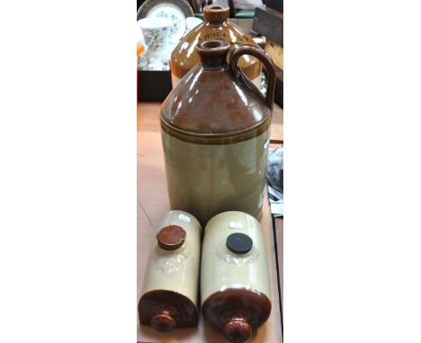 Two vintage stoneware hot water bottles and two large vintage stoneware storage jugs, one for "Geo. Peters & Co Ltd, Wine and