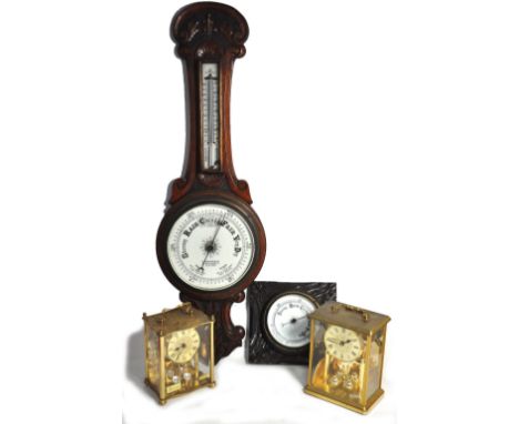 An early 20th century oak wall barometer with carved foliate decoration, a square oak wall barometer and two modern brass qua