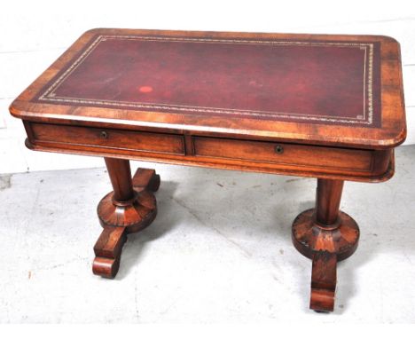 An early Victorian mahogany writing table, the leather lined top above two frieze drawers, on column legs and carved supports