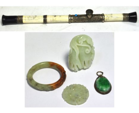 A carved green hard stone bangle, a carved green hard stone token, a carved green hard stone figure group and a carved green 