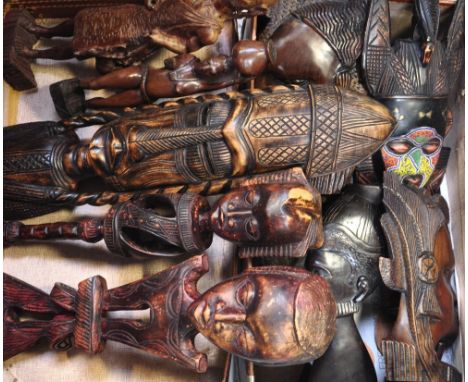 A vintage suitcase containing a quantity of African tribal carvings to include statues, wall plaques, fertility figures, a ma