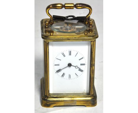 An early 20th century brass carriage clock, white enamel dial set with Roman numerals. CONDITION REPORT Good overall conditio