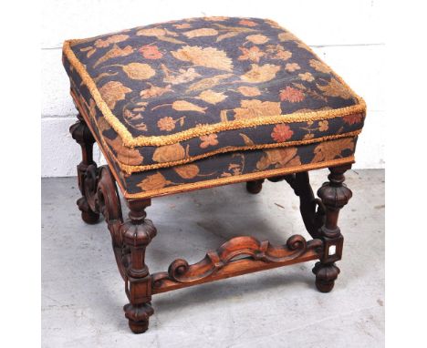 A heavily carved walnut upholstered foot stool.  CONDITION REPORT No visible signs of damage or repairs.