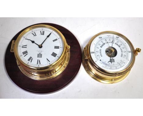 A contemporary Sewills ships type brass barometer/thermometer, diameter 18cm and a matching ships clock on wooden plinth, dia