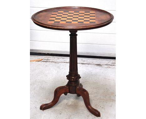 A Victorian occasional table, the dished circular top set with chess top inlay above fluted central column to three scrolling