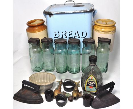 A quantity of kitchenalia to include a blue enamel bread bin, flat irons, metal canisters and stoneware storage jars etc.