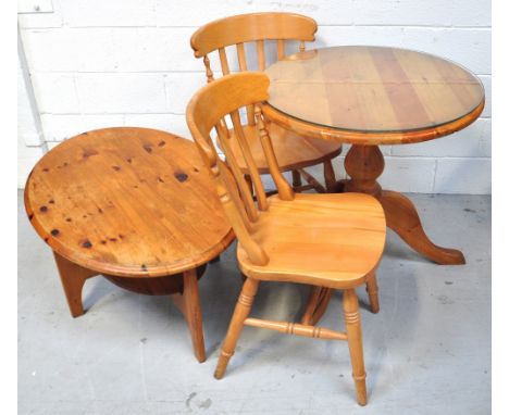 A contemporary pine glass topped dining table of small proportions on tripod support, width 70cm, with a pair of pine chairs 