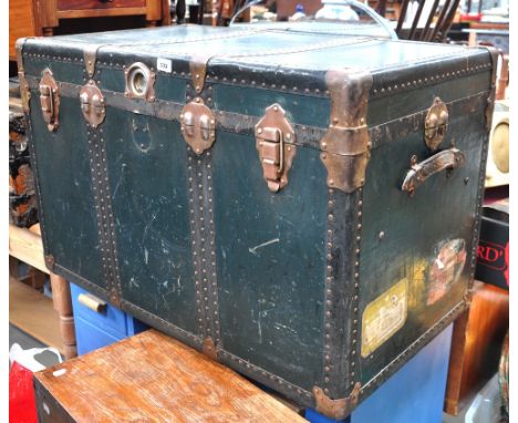 A large green travel trunk with brass fittings, bearing White Star Line and London Midland luggage labels with fitted interio
