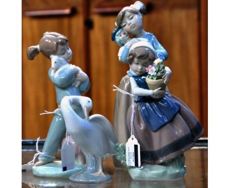 A Lladro figure of a girl holding a pot of flowers, a Lladro model of a goose, a Nao figure of a girl holding a lamb with an 