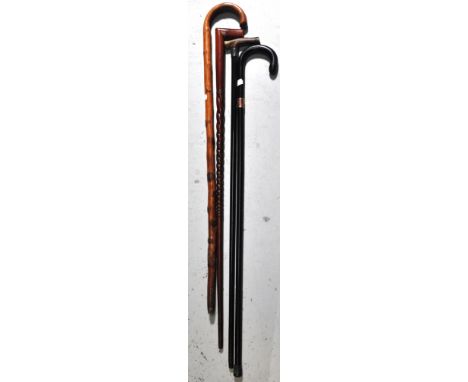 Four vintage walking canes, one with a horn handle and a silver collar, Birmingham date mark rubbed and one ebonised with a h