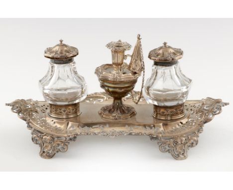 A VICTORIAN PIERCED SILVER INKSTAND the detachable taperstick flanked by silver mounted, faceted glass inkwells, chained coni