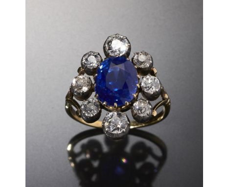 A FINE BELLE EPOQUE SAPPHIRE AND DIAMOND CLUSTER RING the oval sapphire approx 6.6 ct and of intense royal blue, the surround