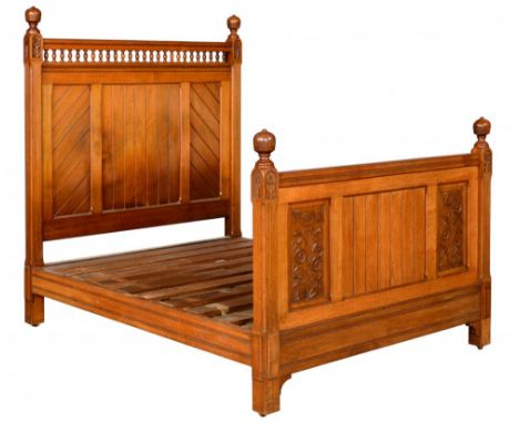 A VICTORIAN REFORMED GOTHIC WALNUT BED, C1870  with globe finials, a galleried headboard with boarded panels, the footboard w