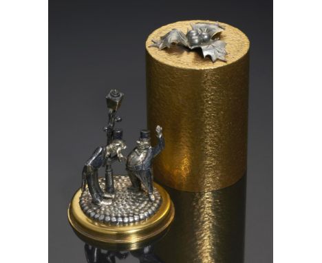 STUART DEVLIN.  AN ELIZABETH II PARCEL GILT SILVER CYLINDRICAL  BOX AND COVER  with surprise of two  drunks by a lamppost, 6.