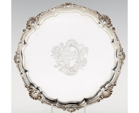 A GEORGE II SILVER SALVER  engraved with contemporary armorials, the gadrooned rim with double shells at intervals,  on four 