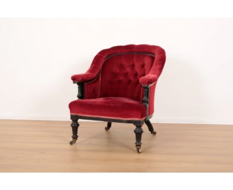A VICTORIAN EBONISED TUB ARMCHAIRwith red velvet button back covers, on turned front legs and outswept rear legs terminating 