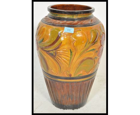 A large early 20th Century Art Nouveau pottery vase / stick stand of bulbous form having hand painted floral decoration.