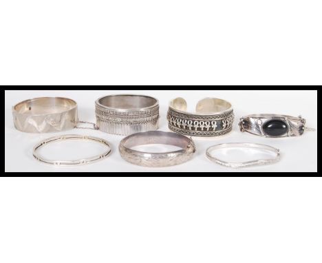 A group of seven silver hallmarked and sterling silver bangle bracelets two include a large hallmarked example with engraved 