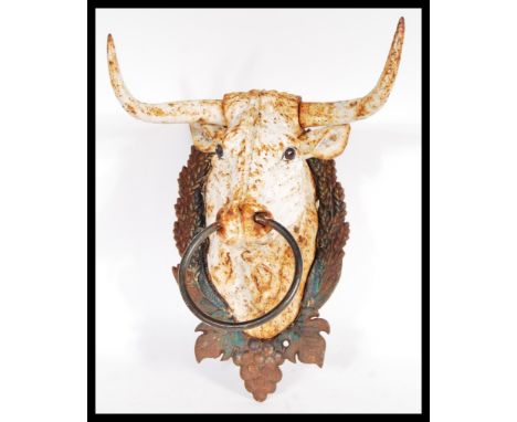 A&nbsp; 20th Century cast iron horse teather in the form of a cow / bull having grape and vine back plate with large ring to 