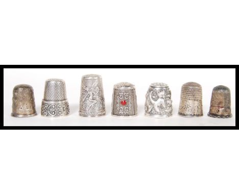 A group of seven hallmarked silver and sterling silver 925 decorative thimbles to include a relief decorated playful kitten e