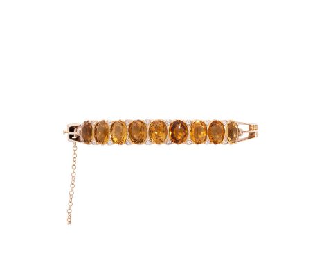 Armreif mit 9 Citrinen und kleinen Diamanten zus. ca. 0,1 ct, Citrine oval facettiert, tlw. min. bestoßen, GG 14K, 21,9 g, In